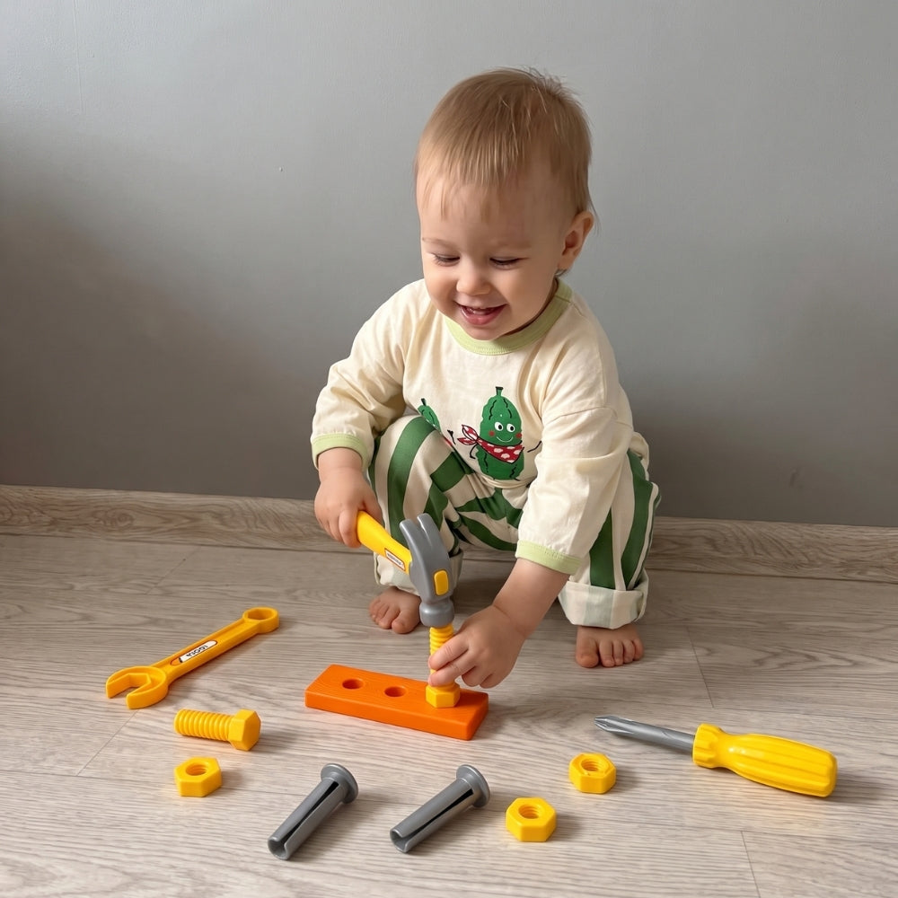 Enfant jouant au petit bricoleur avec un coffret d’outils jouet