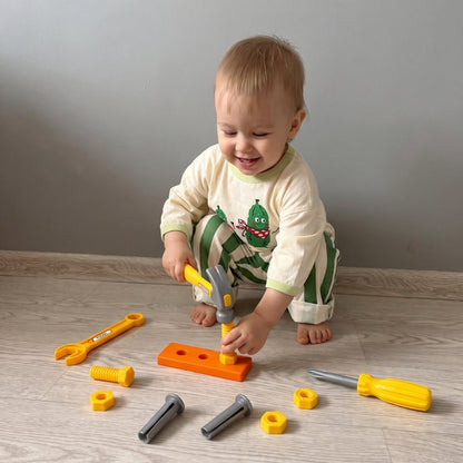 Enfant jouant au petit bricoleur avec un coffret d’outils jouet