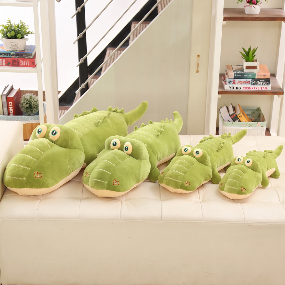 Peluche crocodile allongée prête à accompagner les câlins